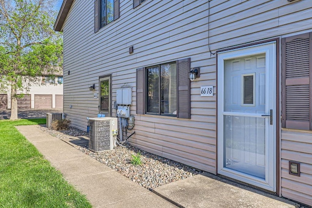 entrance to property with central air condition unit and fence