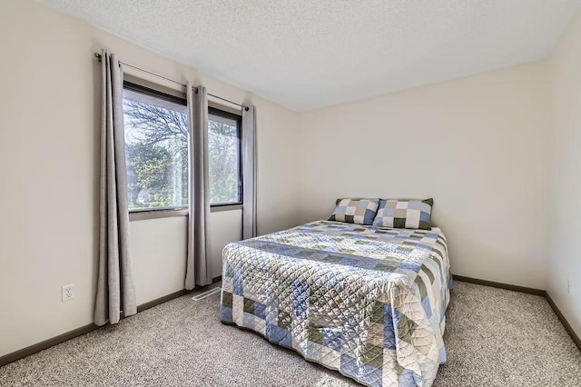 carpeted bedroom featuring baseboards and a textured ceiling