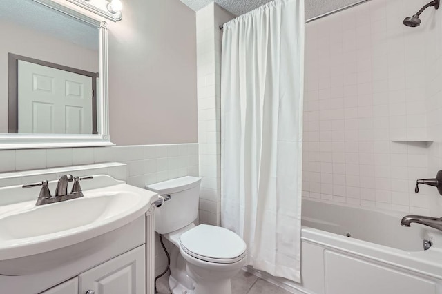 full bathroom with vanity, toilet, shower / bath combo, tile walls, and tile patterned floors