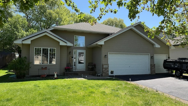 view of front of property featuring an attached garage, driveway, and a front yard