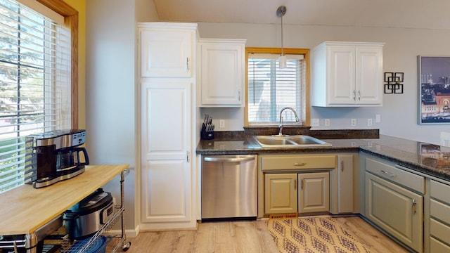kitchen with stainless steel dishwasher, a sink, light wood-style floors, white cabinetry, and pendant lighting
