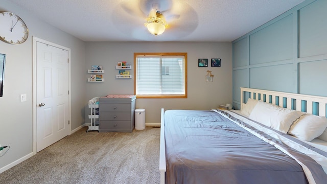 bedroom featuring carpet flooring, baseboards, ceiling fan, and a textured ceiling