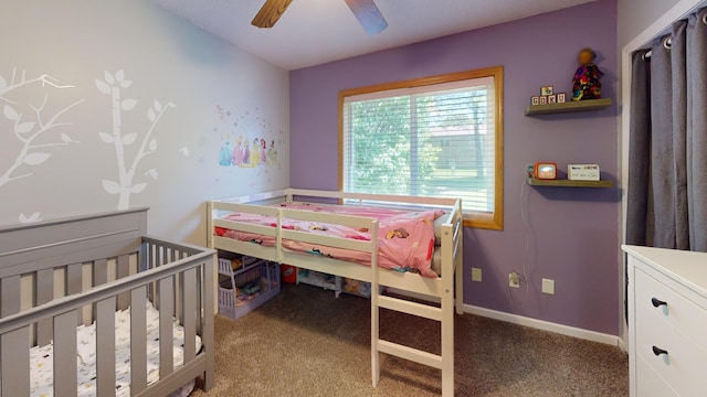 bedroom with carpet floors, ceiling fan, and a crib
