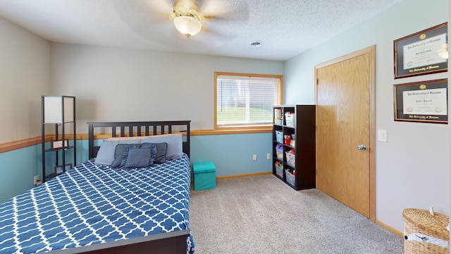 bedroom with carpet, a ceiling fan, baseboards, and a textured ceiling