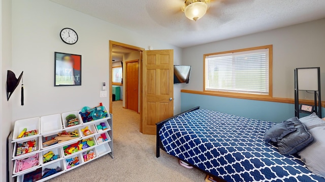 bedroom featuring carpet flooring, a textured ceiling, and a ceiling fan