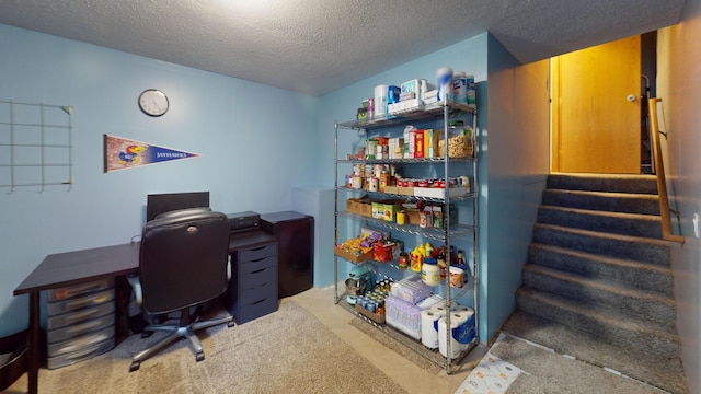 carpeted home office featuring a textured ceiling