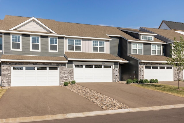 16386 Jaffna Pl, Lakeville, MN 55044 - townhome / multi-family property featuring a garage, driveway, and stone siding