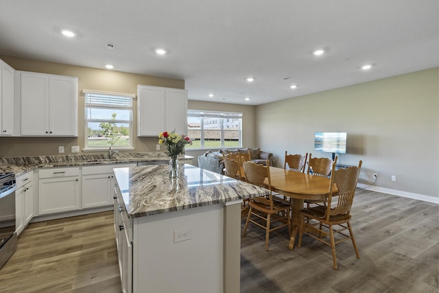 16386 Jaffna Pl, Lakeville, MN 55044 - kitchen featuring a kitchen island, light stone countertops, wood finished floors, recessed lighting, and white cabinets