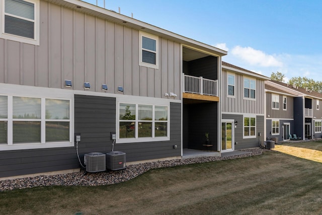 16386 Jaffna Pl, Lakeville, MN 55044 - rear view of property with a balcony, board and batten siding, central AC unit, and a lawn