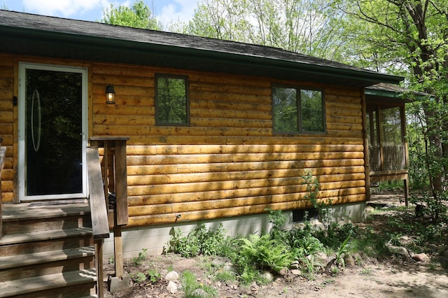 view of front of home with log veneer siding and roof with shingles