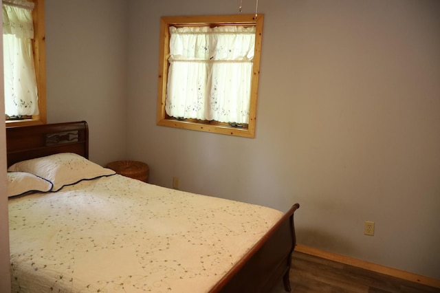 bedroom featuring wood finished floors and baseboards