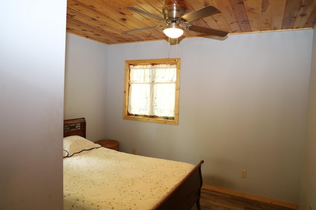 bedroom with wooden ceiling, dark wood-style flooring, baseboards, and a ceiling fan