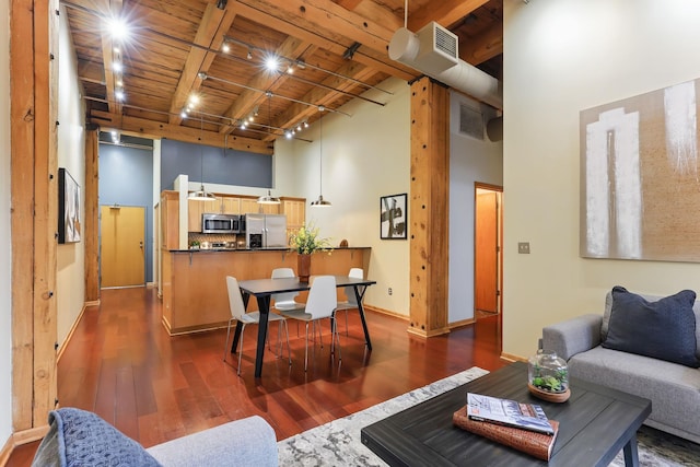 living room with wooden ceiling with exposed beams, dark wood-style flooring, a high ceiling, and baseboards