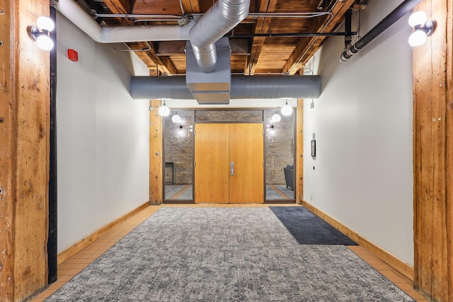 below grade area featuring baseboards and tile patterned flooring