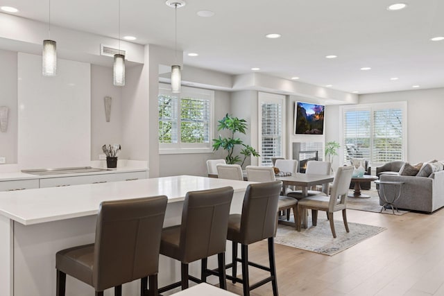 415 Indian Mound St Unit 302, Wayzata, MN 55391 - dining room featuring light wood-type flooring, recessed lighting, and a glass covered fireplace