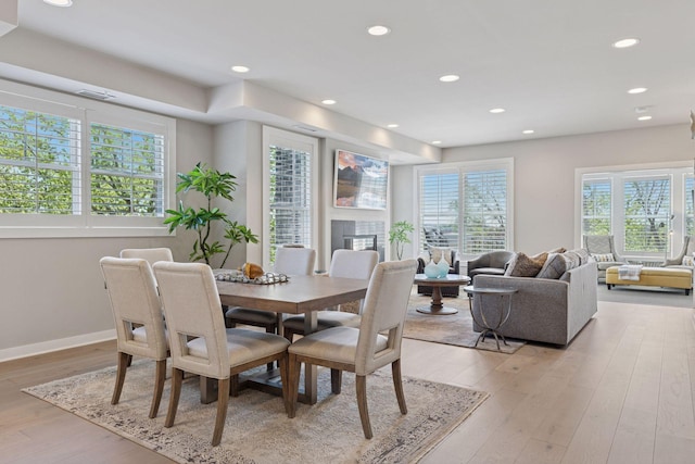 415 Indian Mound St Unit 302, Wayzata, MN 55391 - dining space featuring a glass covered fireplace, recessed lighting, light wood-style flooring, and baseboards