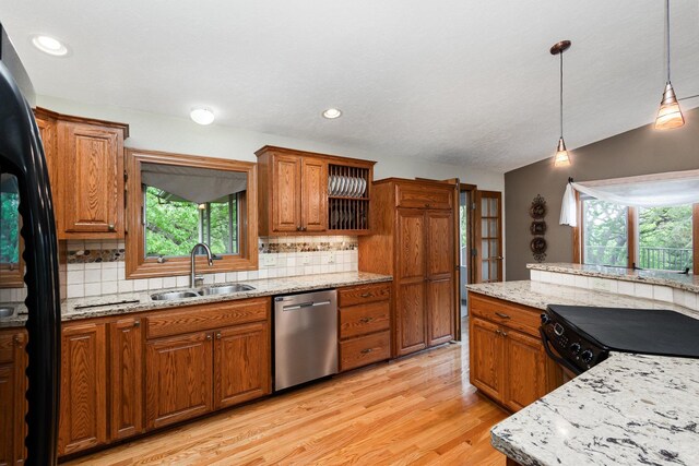 kitchen with dishwasher, a sink, brown cabinetry, healthy amount of natural light, and recessed lighting