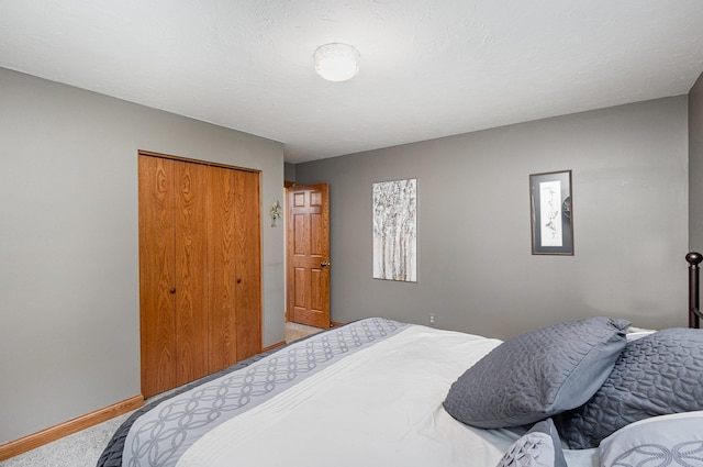 bedroom featuring carpet flooring, baseboards, and a closet