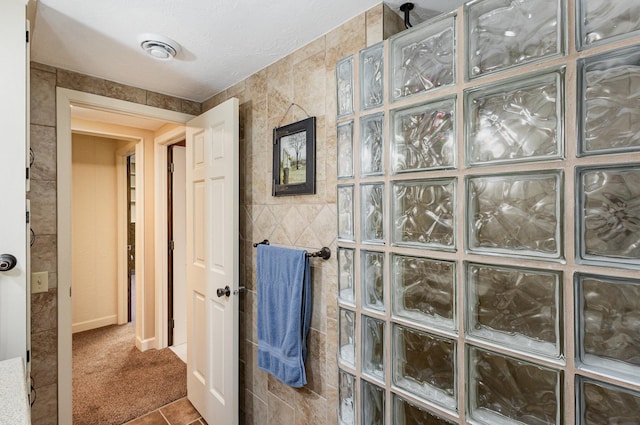 full bathroom with a walk in shower and tile walls