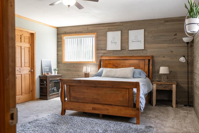 bedroom featuring carpet, wood walls, and ceiling fan
