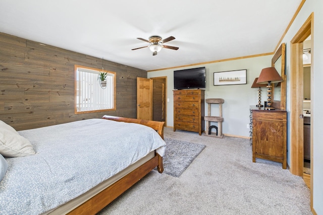 carpeted bedroom featuring wooden walls, a ceiling fan, and baseboards