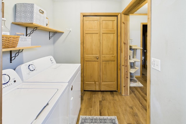 laundry area with independent washer and dryer and light wood-style flooring