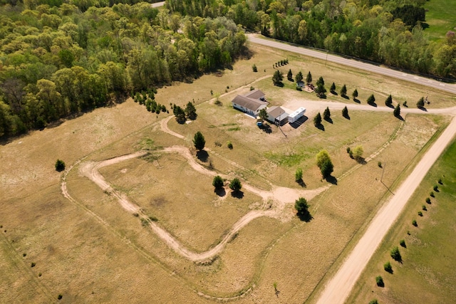 view of property location with rural landscape and a heavily wooded area