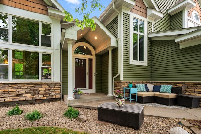 doorway to property featuring stone siding and an outdoor living space