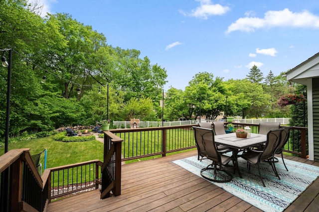 wooden deck with outdoor dining area and view of scattered trees