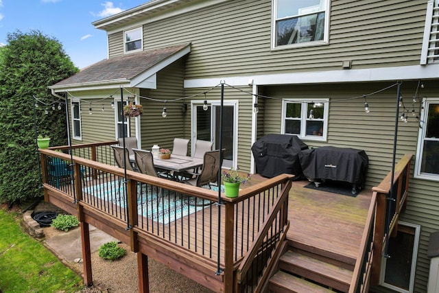 wooden deck featuring a grill and outdoor dining area