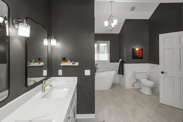 2 Edgcumbe Pl, Saint Paul, MN 55116 - bathroom with a soaking tub, double vanity, a chandelier, tile walls, and toilet