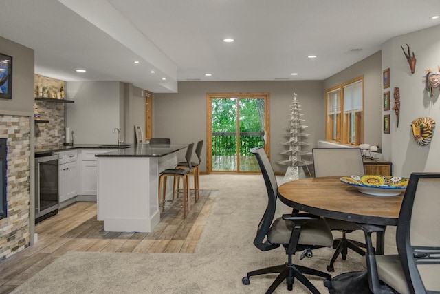 2 Edgcumbe Pl, Saint Paul, MN 55116 - dining space featuring beverage cooler, recessed lighting, bar with sink, light wood-style flooring, and a stone fireplace