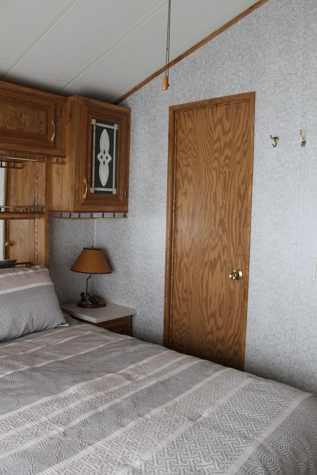 39624 Crane Lake Dr, Clitherall Twp, MN 56515 - bedroom featuring vaulted ceiling, wallpapered walls, and crown molding