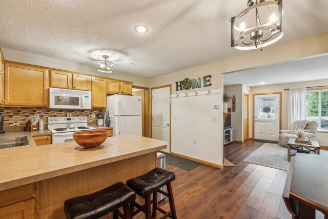 8289 Delaney Dr Unit 24, Inver Grove Heights, MN 55076 - kitchen featuring white appliances, a textured ceiling, a chandelier, light countertops, and a peninsula