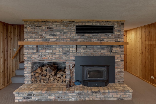 detailed view of wood walls, carpet flooring, a textured ceiling, a fireplace, and baseboards