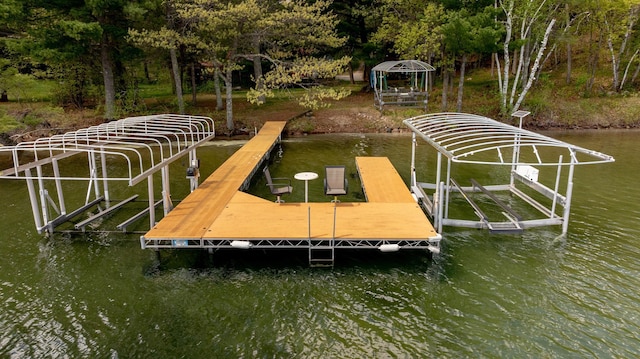dock with boat lift, a gazebo, and a water view