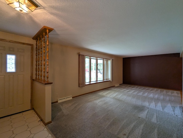 entryway featuring light colored carpet, baseboards, and a textured ceiling