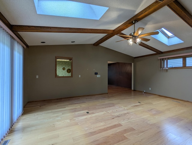 unfurnished room with a skylight, light wood-style floors, and a ceiling fan