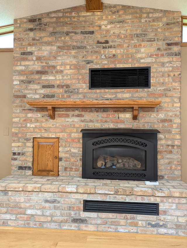 detailed view of a brick fireplace and wood finished floors