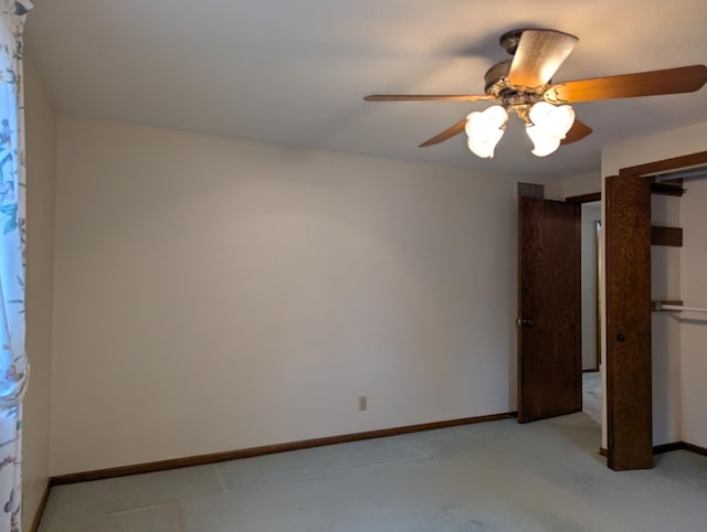 unfurnished bedroom with light carpet, baseboards, a ceiling fan, and a closet