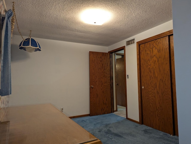 carpeted bedroom featuring a textured ceiling and a closet