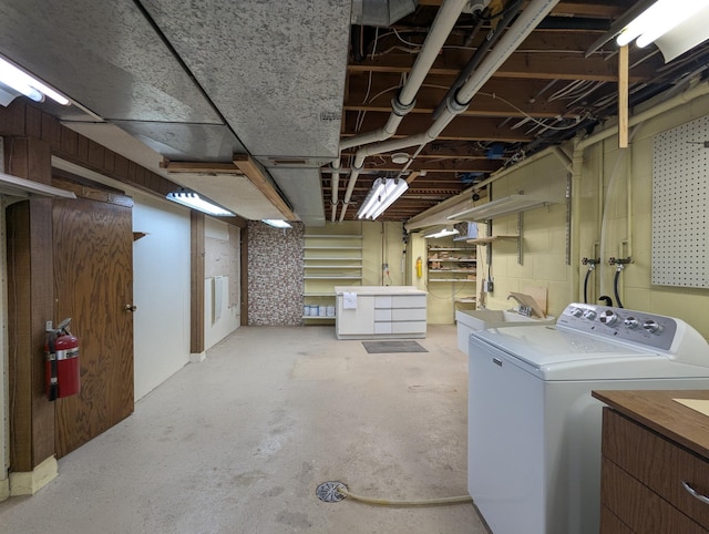 unfinished below grade area with washer / dryer and a sink