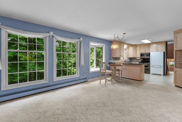 331 Sunset Ln N, Cambridge, MN 55008 - kitchen featuring stainless steel appliances, baseboard heating, dark countertops, light colored carpet, and backsplash