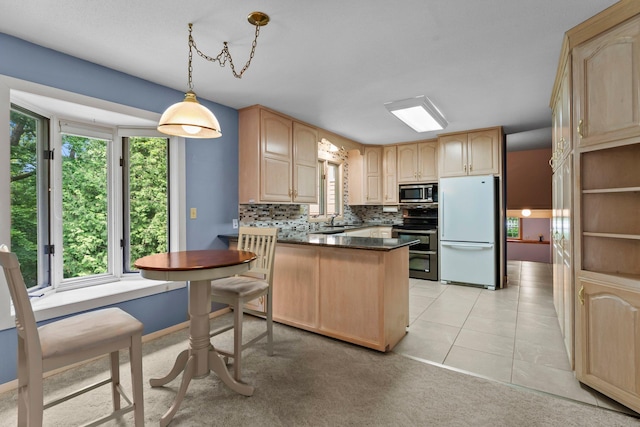 331 Sunset Ln N, Cambridge, MN 55008 - kitchen with stainless steel appliances, light brown cabinetry, a peninsula, and plenty of natural light