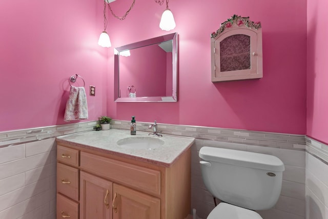 331 Sunset Ln N, Cambridge, MN 55008 - half bathroom featuring tile walls, a wainscoted wall, and vanity