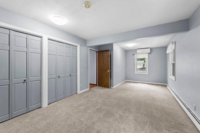 331 Sunset Ln N, Cambridge, MN 55008 - unfurnished bedroom with a baseboard radiator, carpet, a wall mounted AC, multiple closets, and a textured ceiling