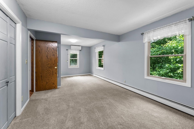 331 Sunset Ln N, Cambridge, MN 55008 - unfurnished bedroom with baseboard heating, carpet, a textured ceiling, a closet, and a wall unit AC