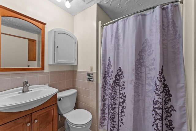 331 Sunset Ln N, Cambridge, MN 55008 - bathroom featuring vanity, tile walls, wainscoting, and a shower with shower curtain