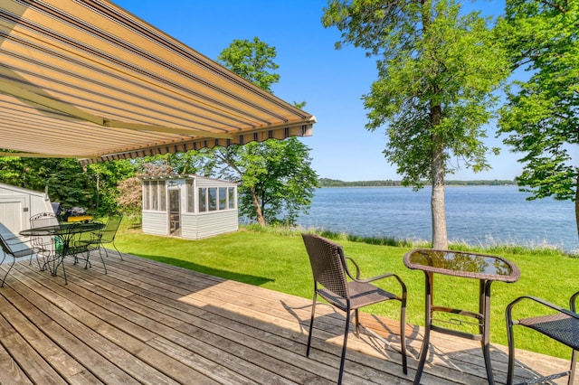 20473 Leisure Dr, Pelican Rapids, MN 56572 - deck featuring a water view, outdoor dining space, and a lawn