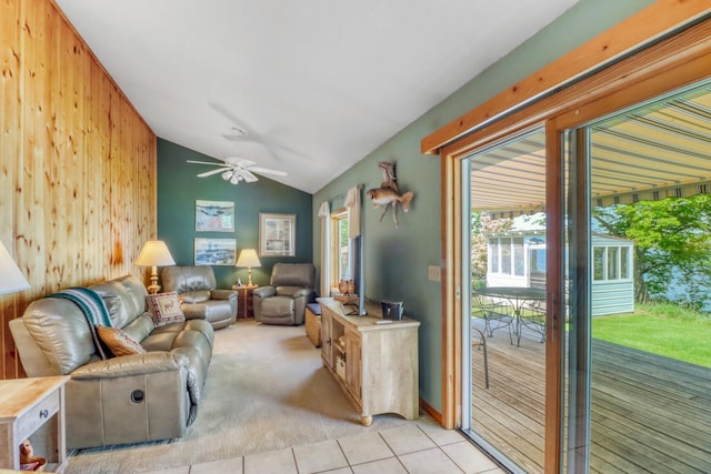 20473 Leisure Dr, Pelican Rapids, MN 56572 - living room featuring light tile patterned floors, vaulted ceiling, wood walls, a ceiling fan, and light colored carpet